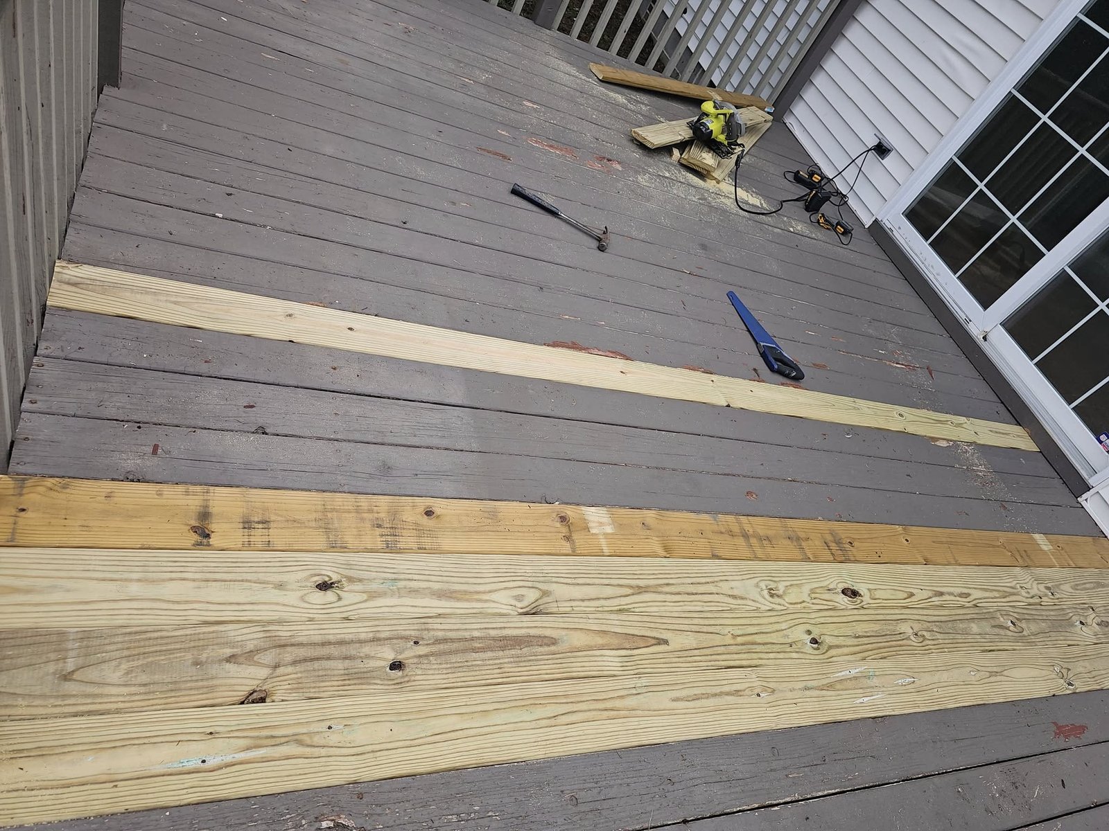 Deck framing under construction with wood planks and tools