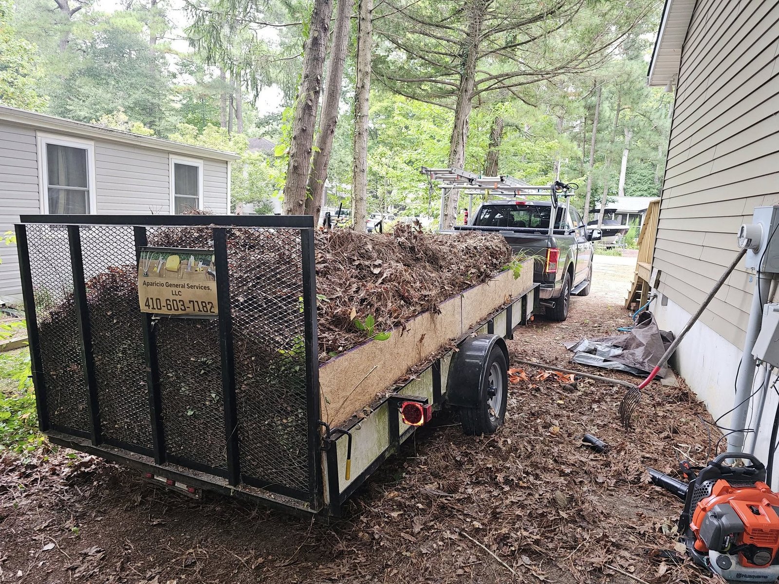 Landscaping trailer loaded with equipment at a job site