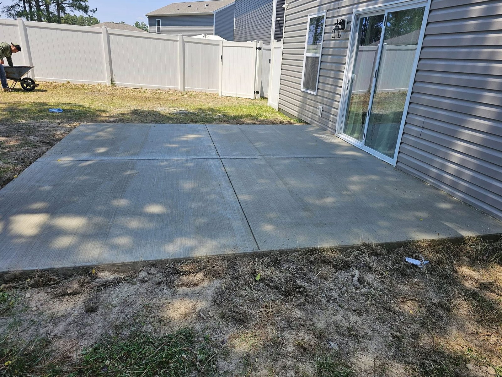 Concrete sidewalk and patio installed next to a house
